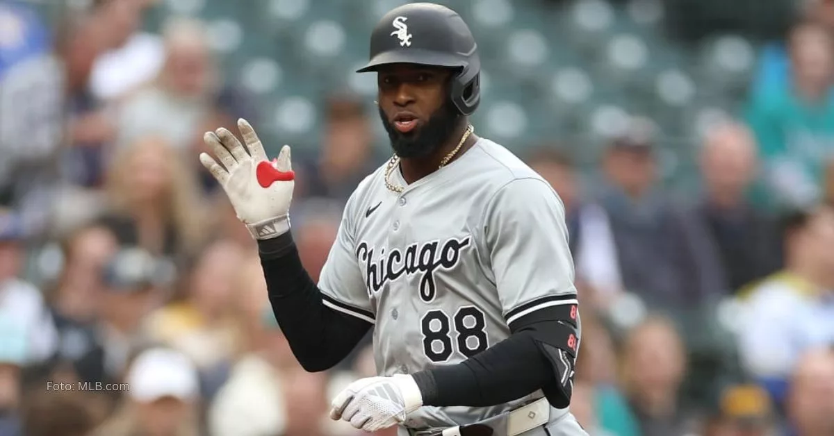 Luis Robert Jr con la goma de agarrar el bate en sus manos y el uniforme gris de Chicago White Sox